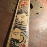 Sangle de guitare avec des visages gravés